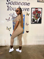 Load image into Gallery viewer, A woman modeling a beige short-sleeve ribbed jumpsuit 
